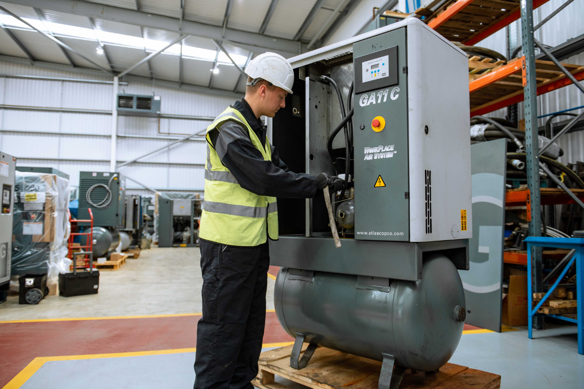 Male engineer carrying out servicing work on a tank mounted screw compressor