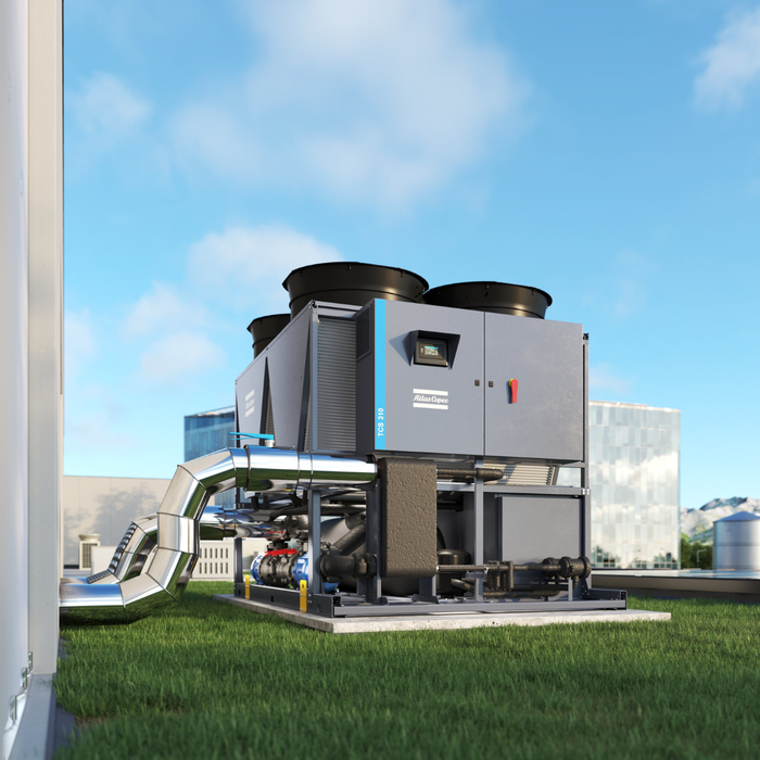 An Atlas Copco TCS industrial chiller in an external setting, blue sky with grass around the machine and mountains in the background.